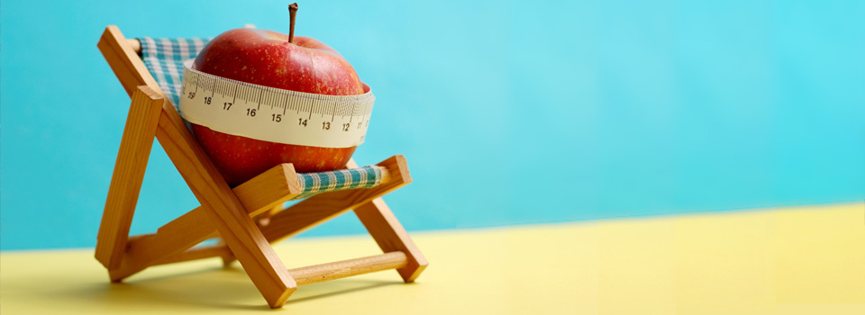 Fruit with tape measure on yellow background